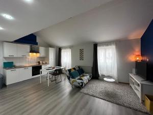 a living room with a couch a table and a kitchen at Studio tendance Charleroi centre in Charleroi