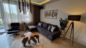 sala de estar con sofá y mesa en FAMILY RESORT SUBOTICA Apartments, en Subotica