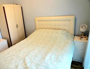 a bedroom with a white bed and a dresser at Kadıköy Yeldeğirmeni'nde daire in Istanbul