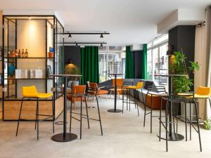 un bar con sillas y mesas amarillas en una habitación en Ibis Pau Centre en Pau