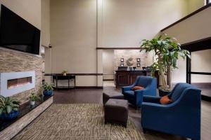 ミッドウェイにあるComfort Inn & Suites Midway - Tallahassee Westのロビー(青い椅子2脚、暖炉付)