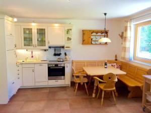 バート・クラインキルヒハイムにあるSunny Villaの白いキャビネット、テーブルと椅子付きのキッチンが備わります。