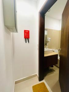 a bathroom with a sink and a red sign on the wall at Ocean breeze Hotel Studio Negombo by Shane in Negombo