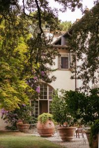 a white house with potted plants in front of it at Exclusive Wine Resort - Villa Dianella in Vinci