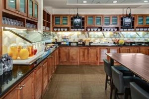 a large kitchen with wooden cabinets and a bar at Hyatt Place Nashville Opryland in Nashville