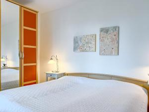 奧茨塞巴德·博爾滕哈格的住宿－Achtern Diek Wohnung 06，白色卧室配有床和灯
