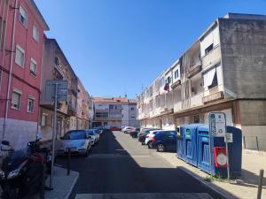 ulica miejska z zaparkowanymi samochodami i budynkami w obiekcie Lisbon traditional T2 with balcony in Damaia, Lisbon w mieście Amadora