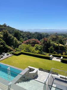 a view of a garden from a house with a swimming pool at Camelot Villa in Cape Town