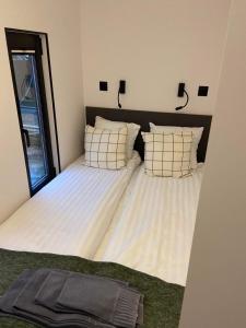 uma cama grande com duas almofadas num quarto em SVANESUND - Hausboot im Herzen von Göteborg em Gotemburgo