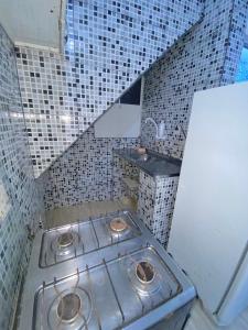 baño con estufa y pared de azulejos en Casa Joaozinho 3, en Morro de São Paulo