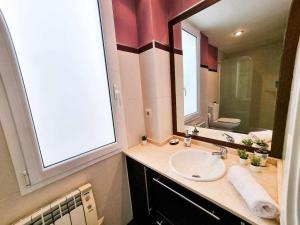 une salle de bain avec un lavabo et un grand miroir dans l'établissement Centric El Secreto del Pilar ComoTuCasa, à Saragosse 44 autres photos