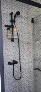 a shower with a black shower head on a wall at Beco do Patalugo in Salir de Matos