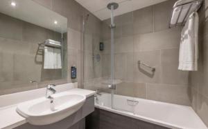 un bagno con un lavandino, una vasca da bagno e un lavandino di Clayton Hotel Galway a Galway