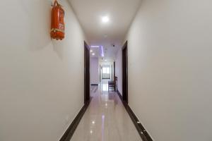 un pasillo con paredes blancas y un pasillo largo en Townhouse Hotel Dj Grand en Tirupati