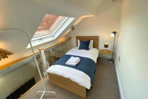 ドンカスターにあるSpacious 4 Bedroom Duplex with Free Private Parking - Central Location, Near Doncaster Racecourse - Sleeps 7の小さなベッドルーム(窓付きのベッド付)