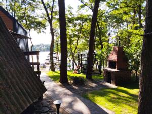 スレシンにあるOSTOJA Ślesinのベンチと木々と水の塊のある公園