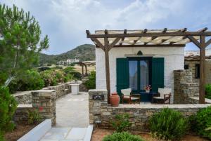 a patio with a pergola and a table and chairs at Villa Peristeri in Agios Georgios