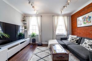 a living room with a couch and a tv at Bright Spacious 2BR Apt, Chancery Lane in London