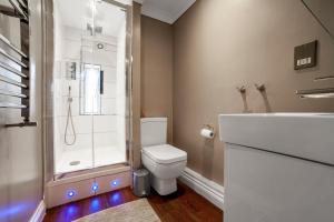 e bagno con doccia, servizi igienici e lavandino. di Bright Spacious 2BR Apt, Chancery Lane a Londra