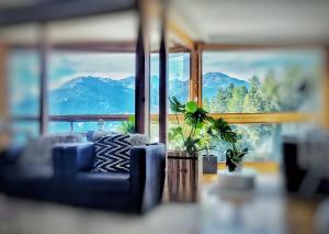 a living room with a blue couch and a large window at L'AvantGardiste, Spacious 6 bedrooms duplex, panoramic view in Crans-Montana