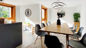 a dining room with a wooden table and chairs at L'AvantGardiste, Spacious 6 bedrooms duplex, panoramic view in Crans-Montana +58 photos