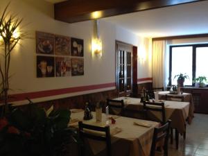 a restaurant with tables and chairs in a room at Hotel Scandola in Bosco Chiesanuova