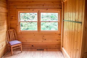 a wooden room with a chair and a window at 23 The Cub House Cabin in Gatlinburg