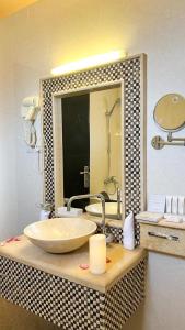 a bathroom with a sink and a large mirror at Levant Hotel in Najran