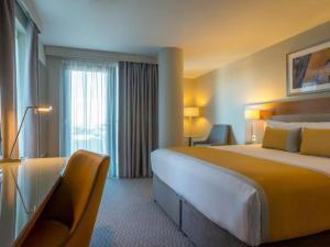una camera d'albergo con un letto grande e una finestra di Maldron Hotel Tallaght a Tallaght
