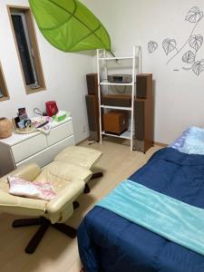 ein Zimmer mit einem Bett und einem Stuhl darin in der Unterkunft B&B legare in Gifu