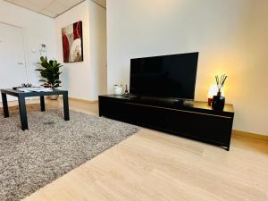 ein Wohnzimmer mit einem Flachbild-TV und einem Tisch in der Unterkunft Urbanstay Suites - Grand Place 2 Bd Penthouse in Brüssel