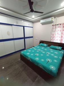 een slaapkamer met een bed met blauwe lakens en witte kasten bij New Premium Fully Furnished 2 BHK Flats Near Station in Tirupati