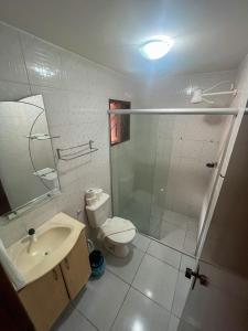 een badkamer met een toilet, een wastafel en een douche bij Pousada Recanto de Ponta Negra in Natal