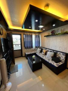 - un salon avec un canapé et une télévision dans l'établissement One Oasis Condo 2 Bedroom Free Pool & Wifi Beside SM City Mall, à Davao
