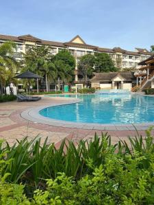 a large swimming pool in front of a building at One Oasis Condo 2 Bedroom Free Pool & Wifi Beside SM City Mall in Davao City
