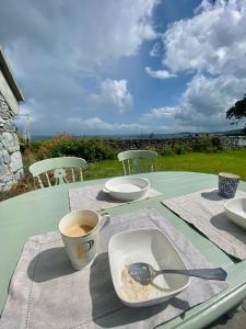 a table with a cup of coffee and a plate with a spoon at Oranuisce Thatch Cottage Ballyvaughan in Ballyvaughan