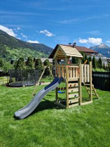 einen Spielplatz mit Rutsche und Spielstruktur in der Unterkunft Apartment Ramazotti in Bad Hofgastein