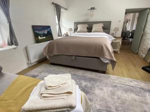 1 dormitorio con 1 cama grande y toallas. en Oranuisce Thatch Cottage Ballyvaughan, en Ballyvaughan