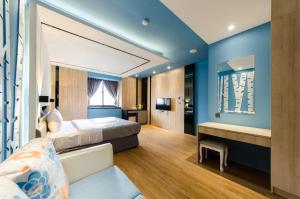 um quarto com paredes azuis, uma cama e um sofá em Julin Motel em Zhushan