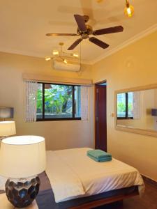 a bedroom with a bed and a ceiling fan at Villa Elodia by Le Duc Hotel & Villas in Mahe