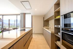 a kitchen with wooden cabinets and a large window at Dobo Marbella Bermeja in Estepona