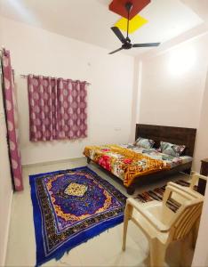 a bedroom with a bed and two rugs on the floor at Deviksha Home Stay in Ujjain