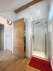 ducha con puerta de cristal y alfombra roja en Contemporary Eco-Home near Bristol Harbourside en Bristol
