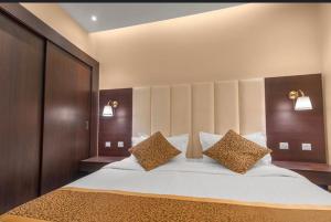 een slaapkamer met een groot bed met 2 kussens bij سكناي صلاح الدين in Hail