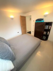 1 dormitorio con cama y estante para libros en Contemporary Eco-Home near Bristol Harbourside en Bristol