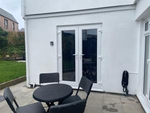 Carbis Bay的住宿－Carbis Bay Suite, Carbis Bay, St Ives, free parking, near beach，大楼前带桌椅的天井