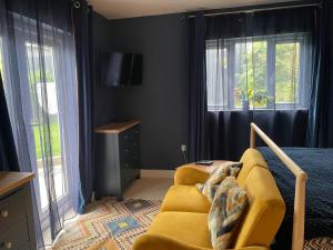 a living room with a yellow couch and windows at Carbis Bay Suite, Carbis Bay, St Ives, free parking, near beach in Carbis Bay