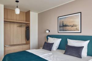 a bedroom with a bed with a blue headboard at Makro Apartments in Hamburg