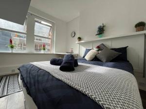 um quarto com duas camas com almofadas azuis em Glasshouse yard studio's F1 em Londres