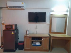a room with a tv and a small table with a microwave at Victory view rayong beach in Ban Chamrung